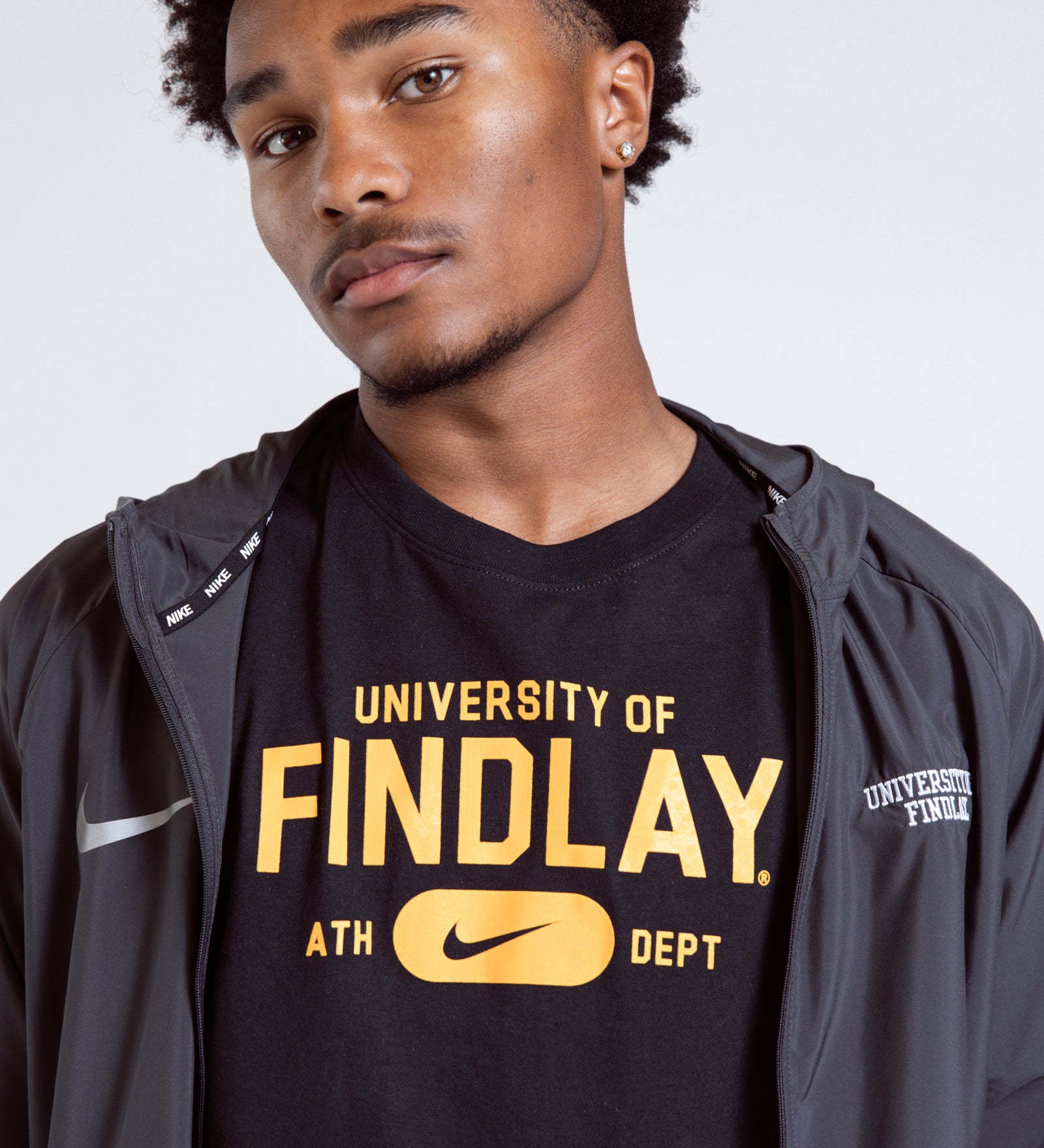 Person wearing a black 'University of Findlay' t-shirt with a gray jacket.