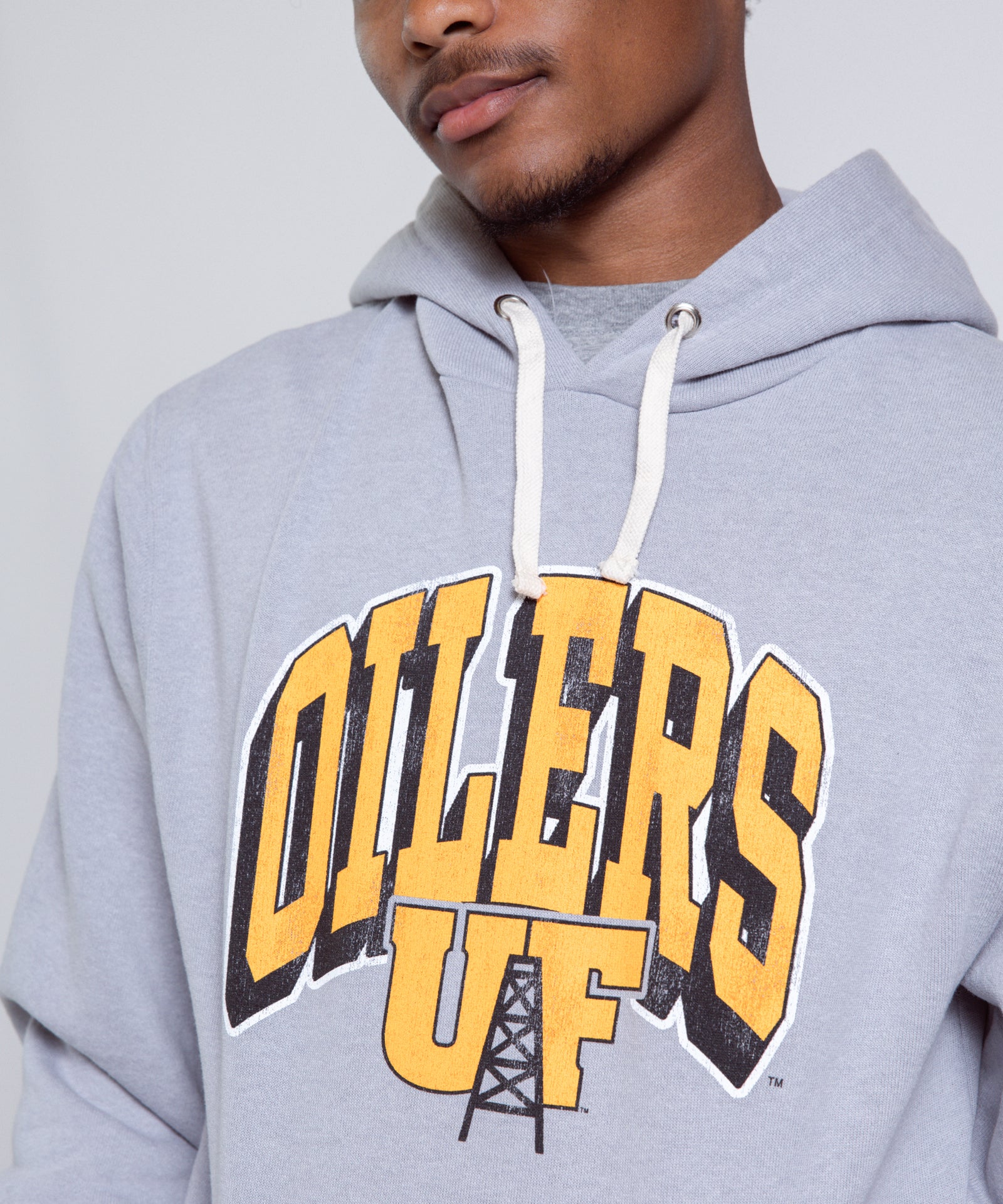 Person wearing a gray hoodie with 'Oilers UF' text on a plain background