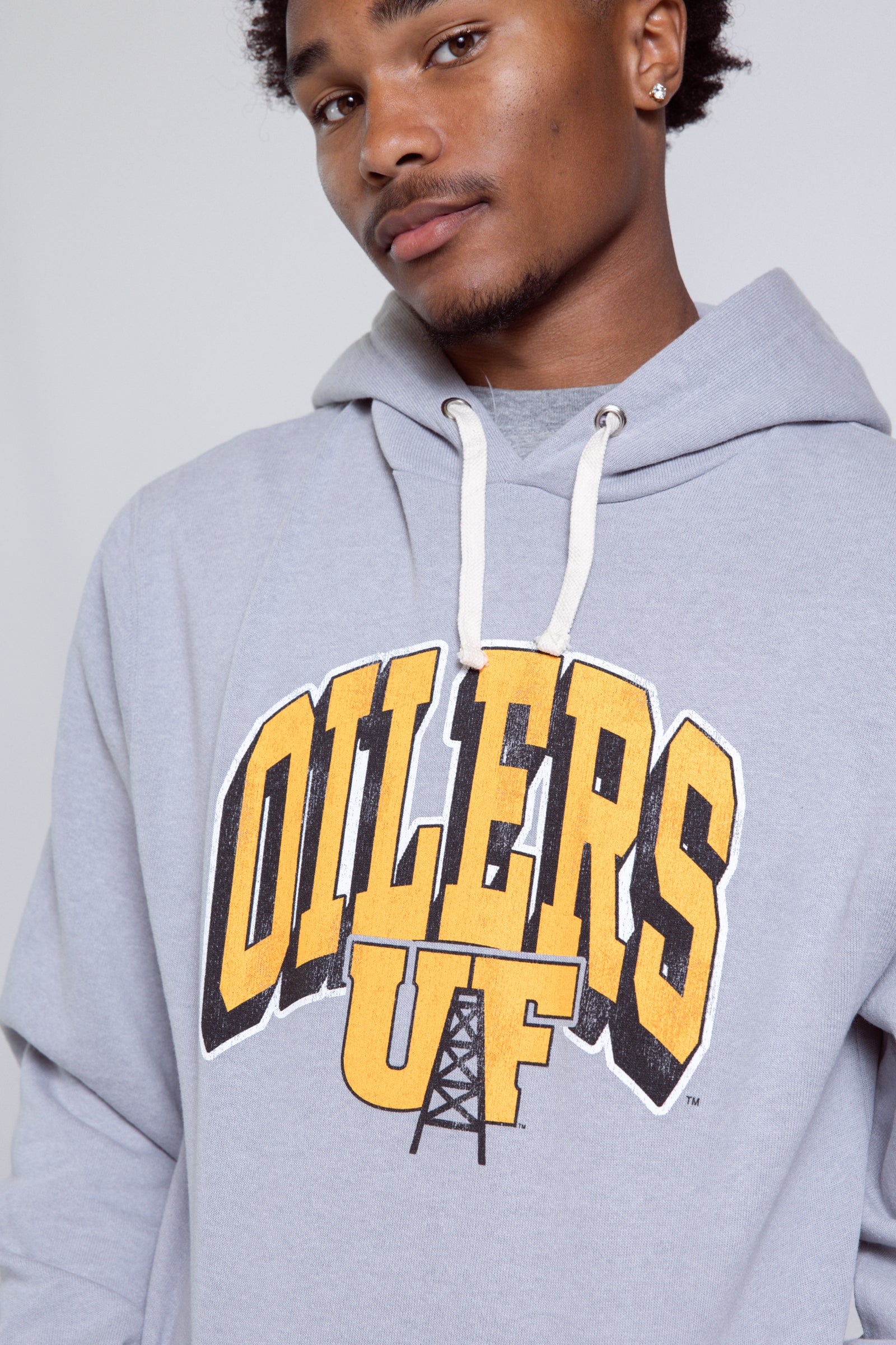 Person wearing a gray hoodie with 'Oilers UF' text on a plain background